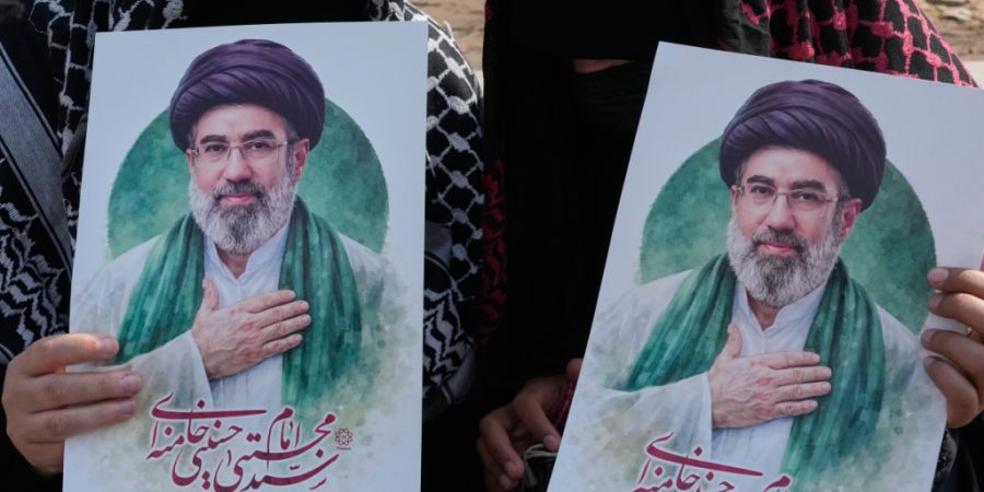 ARCHIV - Frauen halten Plakate des iranischen Staatsoberhaupts Modschtaba Chamenei auf dem Platz der Islamischen Revolution in Teheran. Foto: Vahid Salemi/AP/dpa (Archivbild)