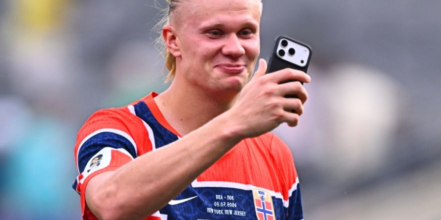 ARCHIV - Der norwegische Kicker Erling Haaland läuft nach dem Spiel mit dem Smartphone in der Hand über den Platz. Ob der Clip auch auf Instagram wandert? Foto: Tom Weller/dpa (Archiv...