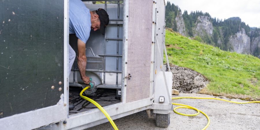 Erich Marty vom Alpgebiet Kaesern in der Gemeinde Oberiberg SZ ist mit seinem aufgefüllten Wassertank von seinem Hof in Unteriberg auf der Alp in Oberiberg angekommen und speisst das W...