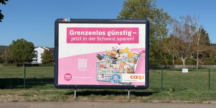 Plakat ennet der Grenze: Coop will EInkafstouris zurückgewinnen.