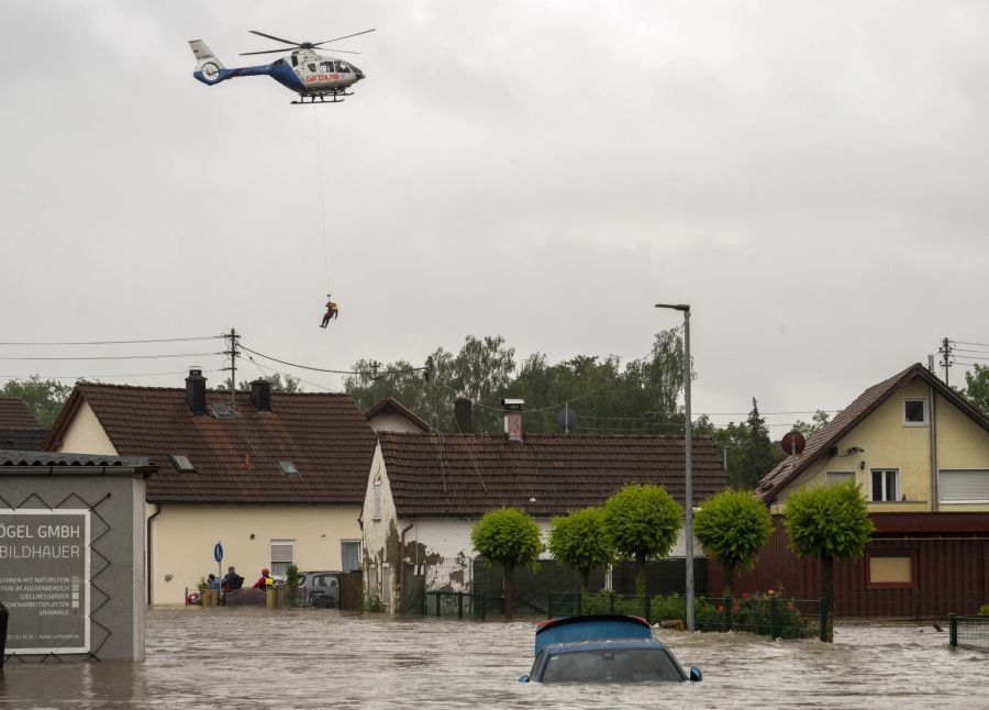 dpatopbilder - 01.06.2024, Bayern, Babenhausen: Aus einem Polizeihubschrauber wird ein Wasserretter abgeseilt. Nach den ergiebigen Regenfällen der letzten Tage gibt es Hochwasser in der Region. Foto: Stefan Puchner/dpa +++ dpa-Bildfunk +++