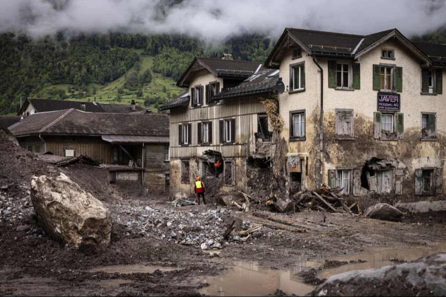 Experten untersuchen im Mai 2024 ein zerstörtes Haus in Schwanden (GL).