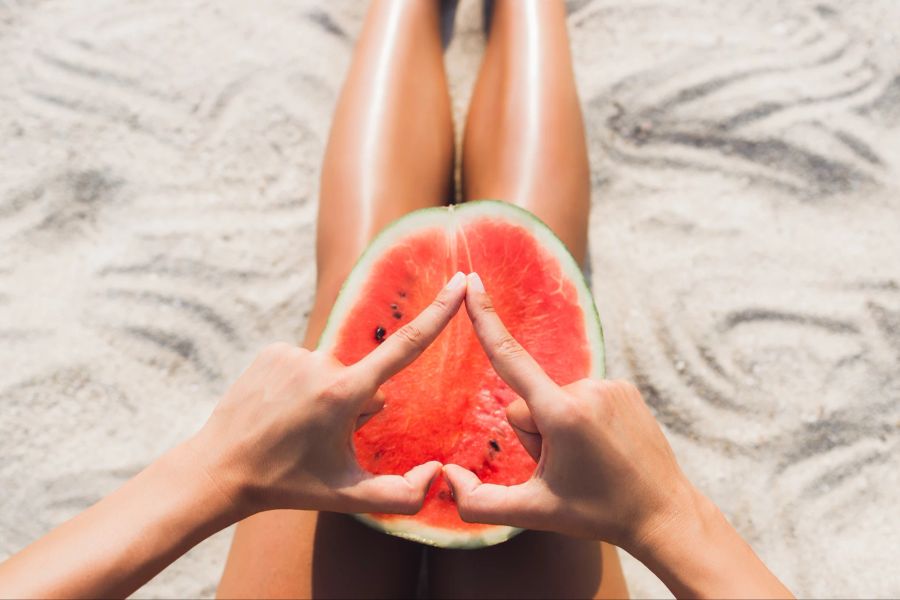 Stockfotografie Frau mit Wassermelone am Strand.