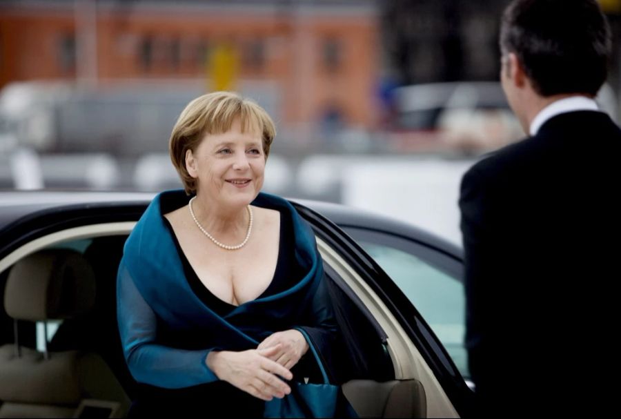 Schwarzes Kleid, türkisfarbener Umhang und eine Tasche: So bekam man Angela Merkel selten zu Gesicht.