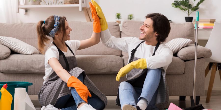 Mann und Frau beim High-Five, Putzen, Ordnung