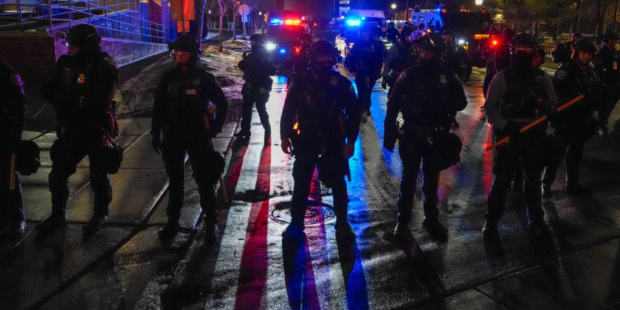 Polizeibeamte aus Minneapolis stehen während einer «Lärmdemonstration» vor einem Hotel, in dem Bundesbeamte untergebracht sind. Foto: Ryan Murphy/FR172324 AP/AP/dpa