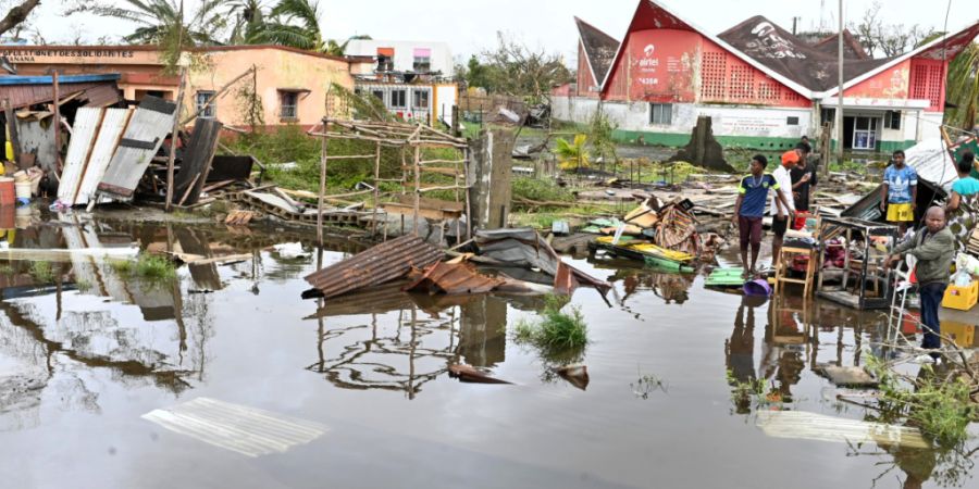 Menschen begutachten die Schäden des Zyklons «Gezani» in Toamasina. Foto: Hery Nirina Rabary/AP/dpa