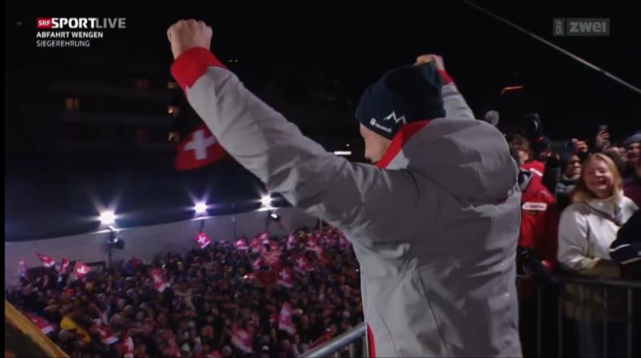 Marco Odermatt feiert an der Siegerehrung nochmal seinen Abfahrtssieg vor den Heimfans in Wengen.