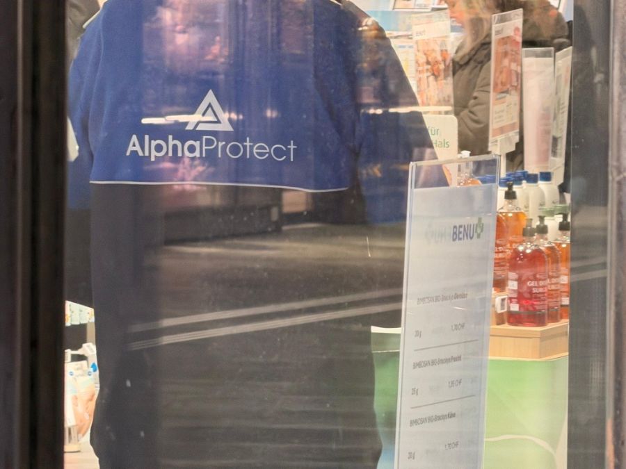 Ein Security steht vor der Apotheke in Luzern.