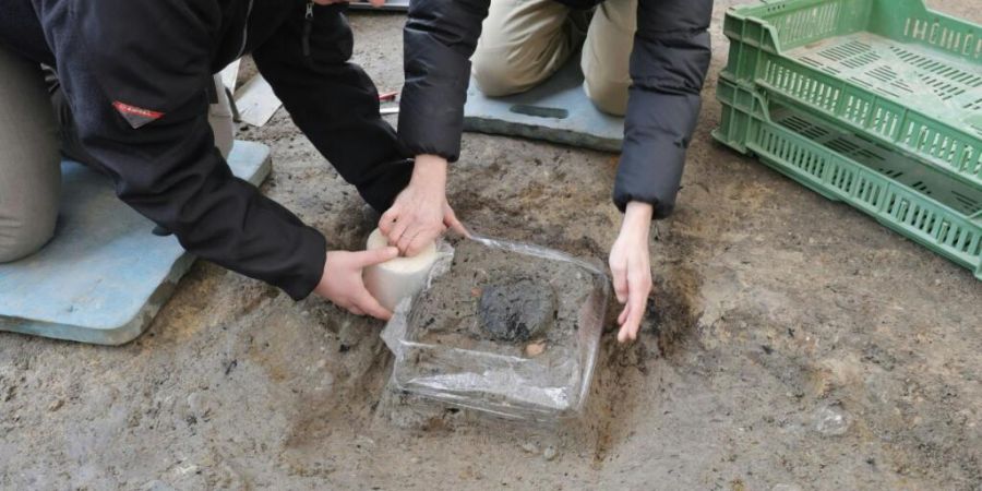 Zwei Restauratorinnen bergen das verkohlte römische Brot in Windisch AG.