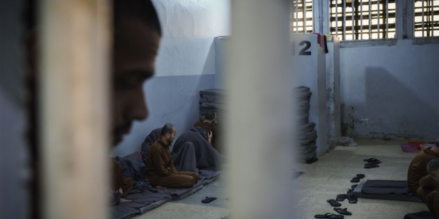 ARCHIV - Häftlinge, die beschuldigt werden, Kämpfer des Islamischen Staates (IS) zu sein, sitzen in einer Zelle des von den Demokratischen Kräften Syriens betriebenen Gweiran-Gefäng...