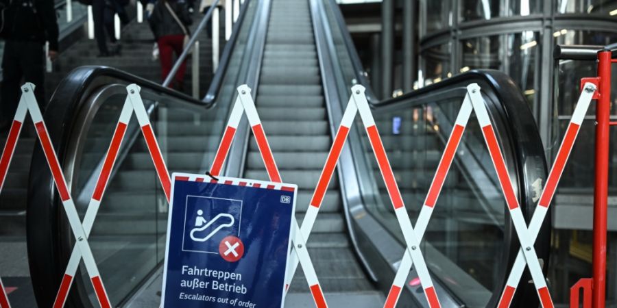 Fahrgäste tragen ihre Koffer am Berliner Hauptbahnhof über die Treppe. Foto: Britta Pedersen/dpa