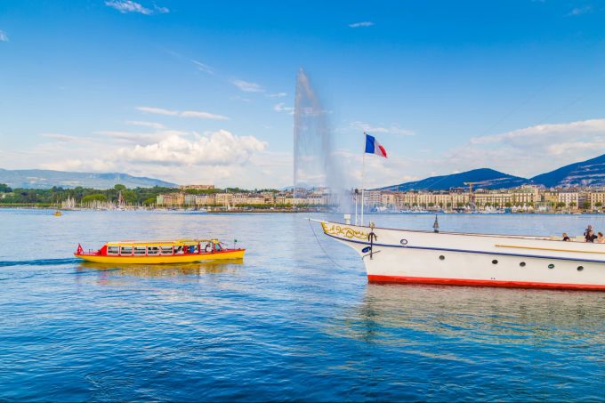 Postkarten-Panorma bietet Genf mit dem Jet d'Eau und den schmucken Booten und Schiffen, die auf dem Genfersee schippern. Genferse, Jet d'Eau