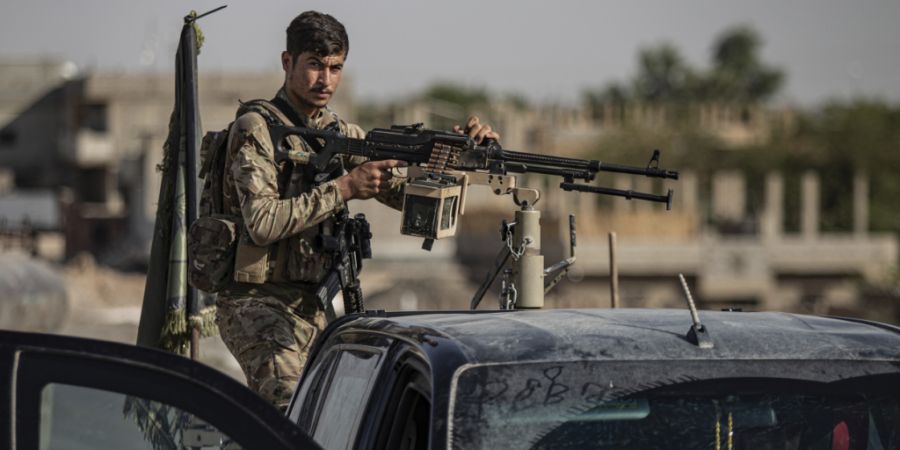 ARCHIV - Ein von den USA unterstützter Kämpfer der Syrischen Demokratischen Kräfte (SDF) steht auf einem gepanzerten Fahrzeug in Ostsyrien. Foto: Baderkhan Ahmad/AP/dpa