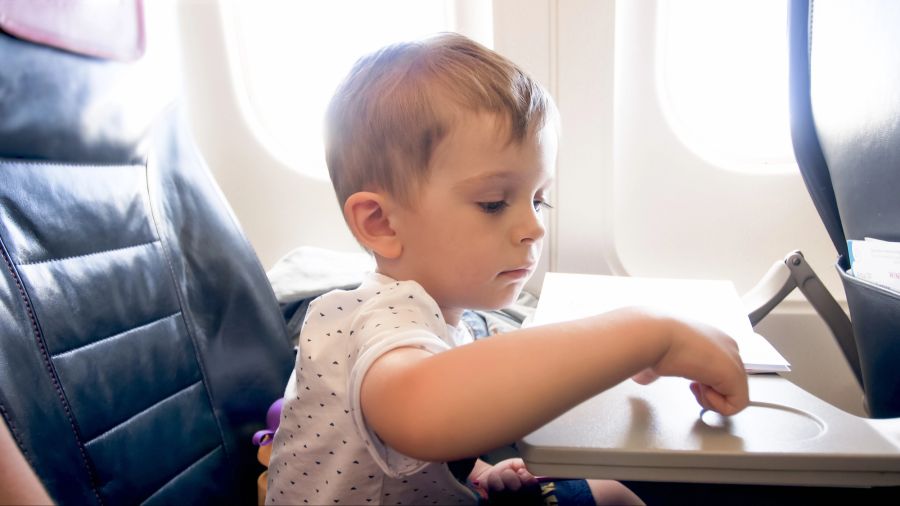 Junge im Flugzeug am Klapptisch