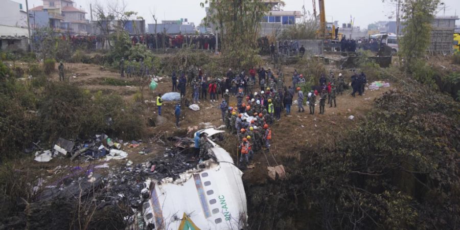 Nach dem Flugzeugabsturz in Nepal dursuchten Rettungskräfte das Wrack nach Überlebenden. Foto: Uncredited/AP/dpa