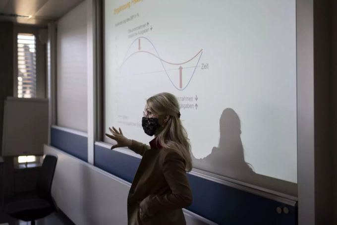 Eine Wirtschaft-und-Gesellschaft-Lehrerin der Wirtschaftsschule KV Zürich unterrichtet die Klasse 21-M2.22 Maske tragend, fotografiert am 25. März 2021 in Zürich. Coronavirus Schulzimmer Lehrperson
