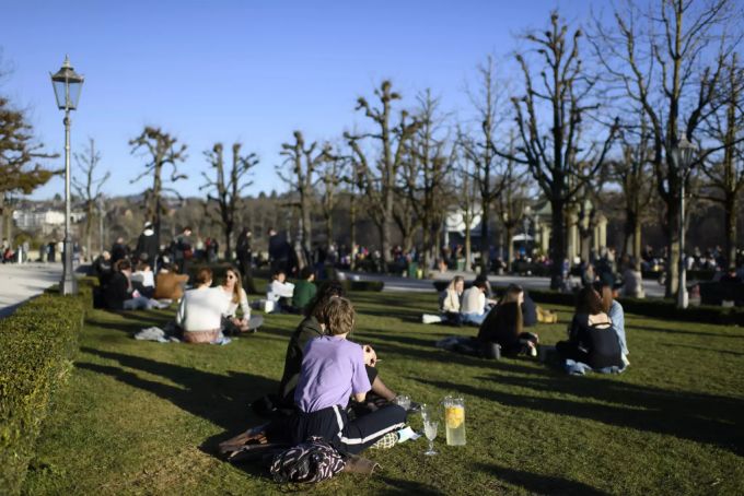 Zahlreiche Menschen geniessen das warme Wetter am Samstag auf der Münsterplattform in Bern. Wetter Sonne warm Temperaturen