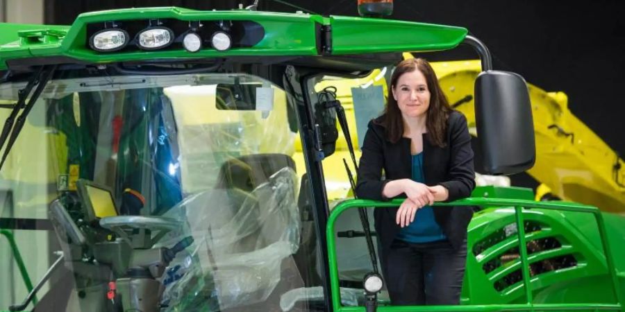 Cornelia Walde steht im John Deere Showroom auf einem Häcksler des Herstellers. Walde leitet das Werk in Zweibrücken (Rheinland-Pfalz). Foto: Oliver Dietze/dpa