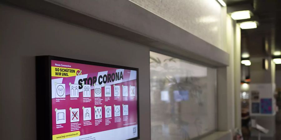 Auf einem Bildschirm wird in einer Schule auf die Corona-Regeln des Bundesamts für Gesundheit hingewiesen. (Archivbild)