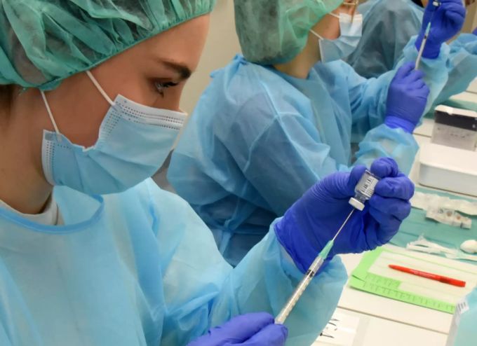 Medizinstudentinnen präparieren den Pfizer-Impfstoff für die Verimpfung. Mit genügend Fingespitzengefühl lassen sich aus jedem Fläschchen sechs statt fünf Dosen gewinnen. Coronavirus sechs Impfdosen Fläschchen