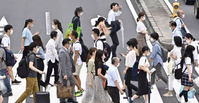 Menschen in Tokio tragen beim Überqueren einer Strasse Mundschutze. Menschen aus Japan dürfen wieder unkompliziert in die EU einreisen. japan