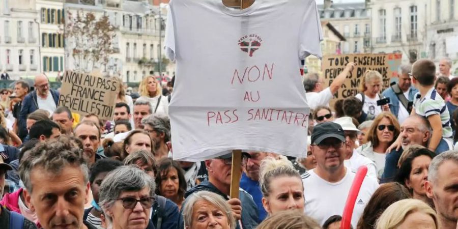 Protestteilnehmer ziehen ohne Mund-Nasen-Schutz durch Biarritz. Foto: Bob Edme/AP/dpa