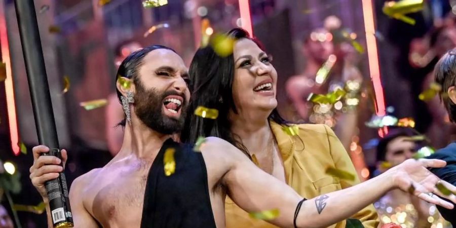 Conchita Wurst (l) feiert Jasmin Shakeri nach der Premiere der neuen Show «Arise», in den Friedrichstadt-Palast. Foto: Britta Pedersen/dpa-Zentralbild/dpa