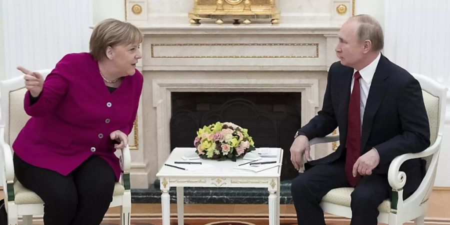 ARCHIV - Bundeskanzlerin Angela Merkel und der russische Präsident Wladimir Putin unterhalten sich im Kreml. Foto: Pavel Golovkin/AP/dpa