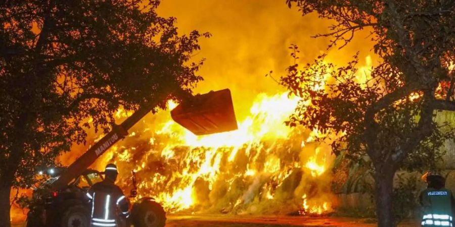 Einsatzkräfte der Feuerwehr löschen im Oktober 2020 einen Brand von rund 400 Strohballen in Gundelsheim. Foto: Franziska Hessenauer/dpa