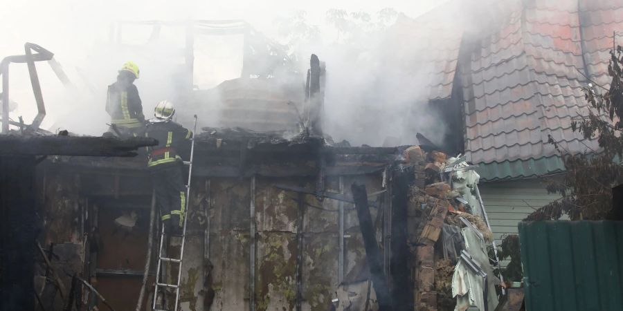 Feuerwehrleute löschen nach einem Raketenangriff nahe Kiew.