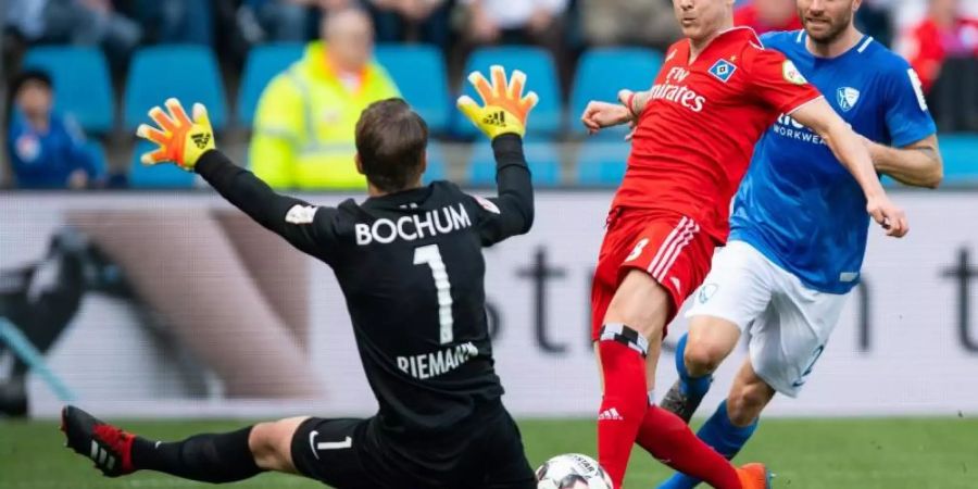 Bochum-Keeper Manuel Riemann (l) schmeisst sich HSV-Profi Lewis Holtby in den Weg. Foto: Guido Kirchner/dpa