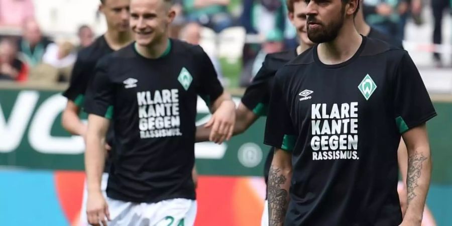 Werders Martin Harnik (r-l) und Johannes Eggestein tragen Trikots mit der Aufschrift "Klare Kante gegen Rassismus". Foto: C. Jaspersen/dpa