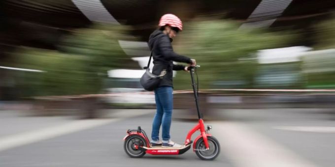 Frau auf einem E-Scooter Frau auf einem E-Scooter