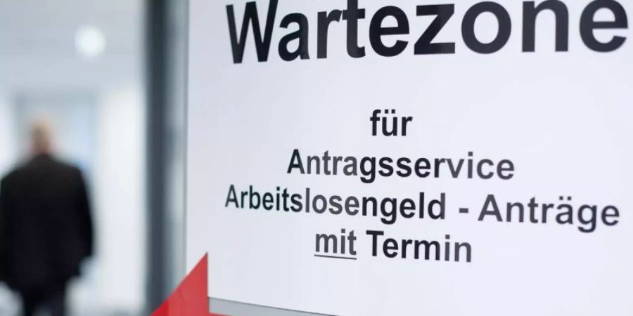 Ein Mann geht in den Wartebereich für den Antragsservice Arbeitslosengeld. Foto: Sebastian Gollnow/dpa