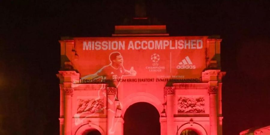 Das Siegestor in München ist nach dem Sieg des FC Bayern München im Finale der Champions League mit dem Schriftzug «Mission Accomplished» beleuchtet. Foto: Felix Hörhager/dpa