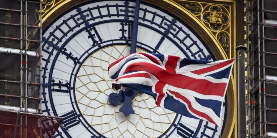 Eine am Ziffernblatt des Big Ben befestigte britische Flagge weht im Wind. Foto: Alberto Pezzali/AP/dpa