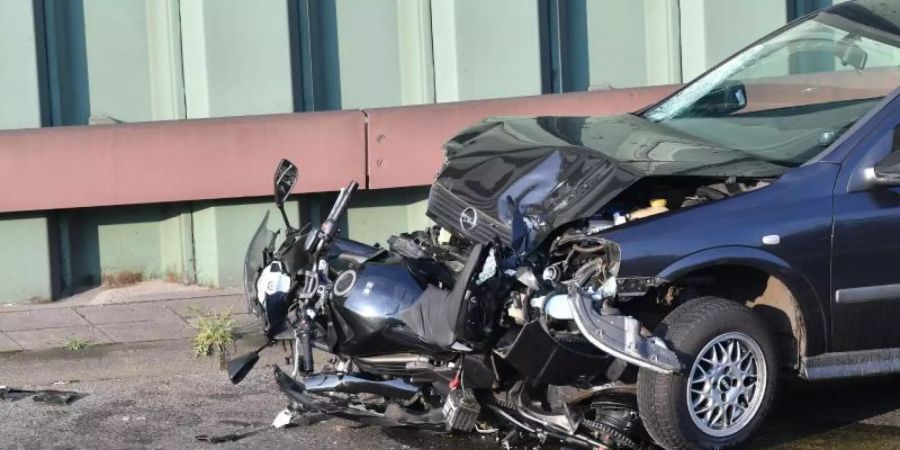 Das bechädigte Tatfahrzeug und ein zerstörtes Motorrad auf der Berliner Stadtautobahn A100 in Höhe der Ausfahrt Alboinstrasse. Foto: Paul Zinken/dpa-Zentralbild/dpa