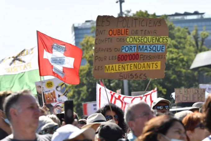 Demonstranten der Anti-Masken-Bewegung halten Flaggen und Schilder mit Parolen bei einem Protest gegen coronabedingte Einschränkungen auf dem Palais des Nations vor dem europäischen Hauptsitz der Vereinten Nationen. Coronavirus - Proteste in der Schweiz