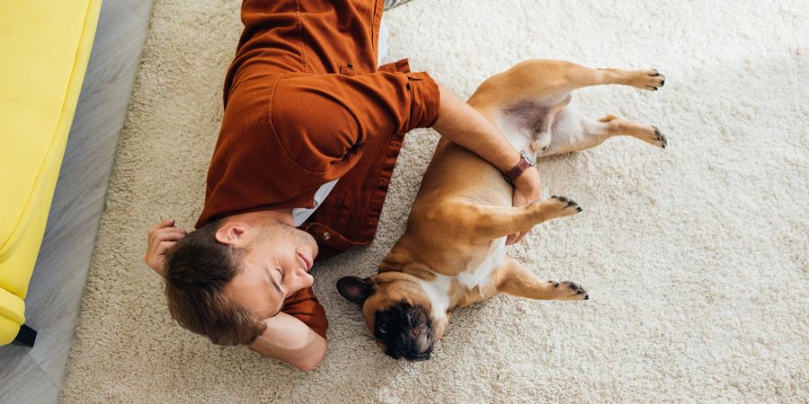 Mann mit Hund auf Teppich