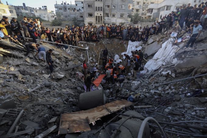 Palästinenserinnen und Palästinenser versammeln sich um ein im Israel-Krieg zerstörtes Haus. Israel-Krieg
