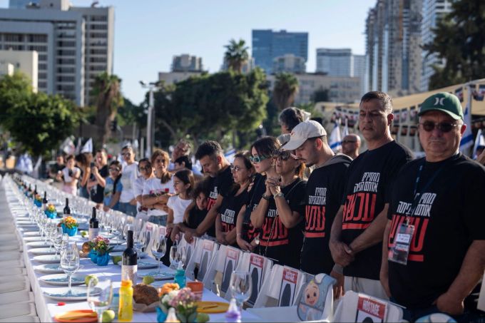 Angehörige von Menschen, die von Hamas-Kämpfern entführt wurden, beten in Tel Aviv umgeben von 203 leeren Stühlen. Petros Giannakouris/AP/dpa Angehörige von Geiseln in Tel Aviv
