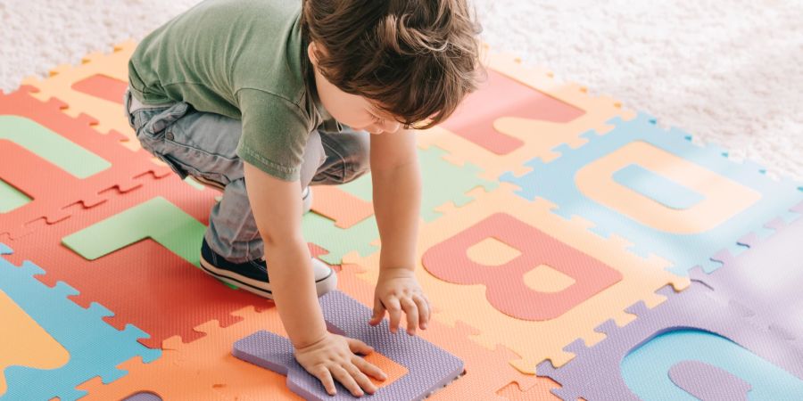 kleinkind spielt mit buchstaben