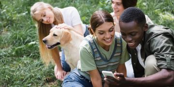 Teenager mit Hund auf Wiese