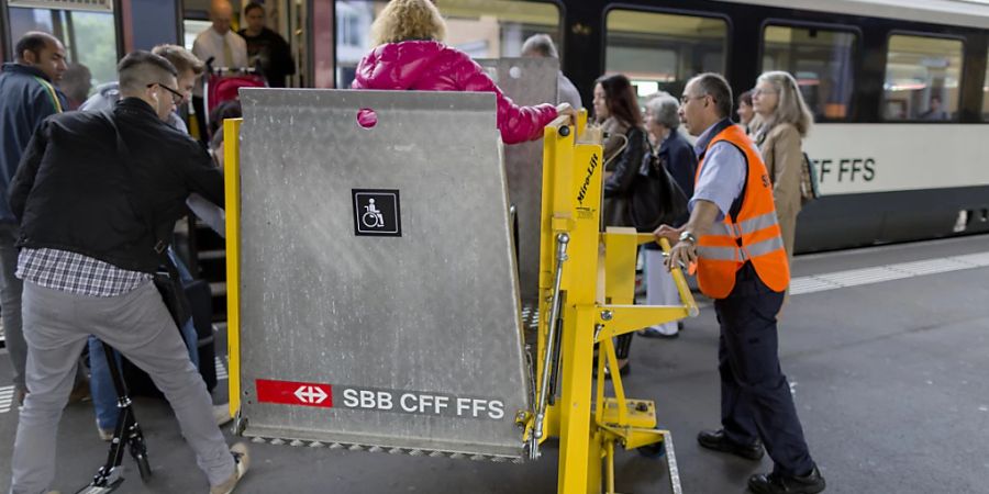 Eine Rollstuhlfahrerin erhält Hilfe beim Einsteigen in den Zug. (Archivbild)