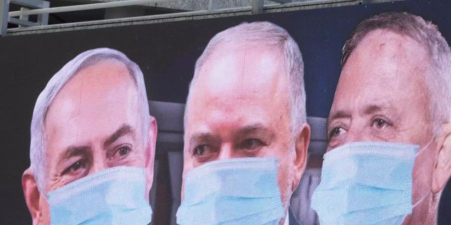 Grosse Qualition in Israel: Premierminister Benjamin Netanjahu, Rechtsaussen Avigdor Lieberman und Oppositionsführer Benny Gantz (von links) mit Mundschutz auf einem Plakat in Tel Aviv.