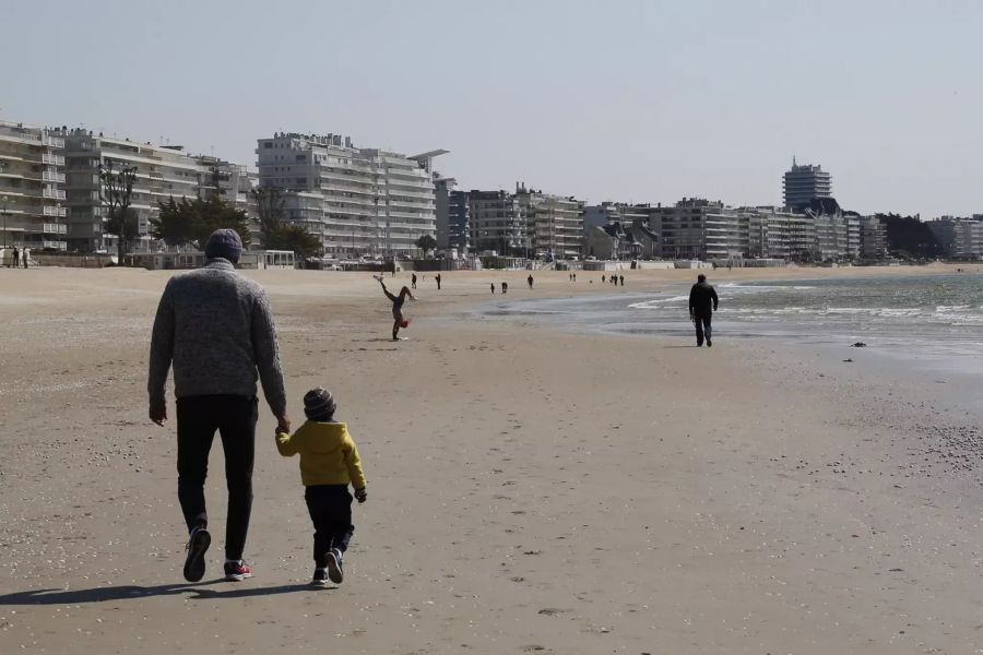 Menschen spazieren am Donnerstag, 14. Mai, am Strand in La Baule.