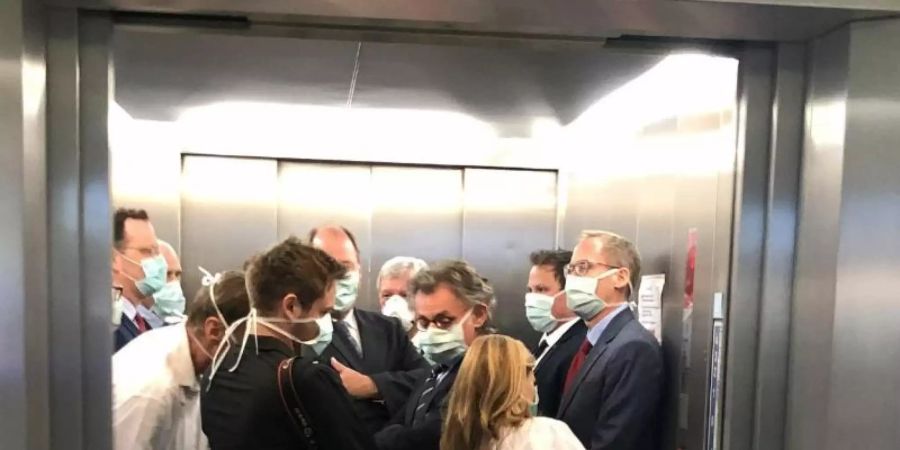 Bei einem Besuch der Uniklinik Giessen drängen sich Bundesgesundheitsminister Spahn (CDU, l), und Hessens Ministerpräsident Bouffier (CDU, M) mit Begleitern im Fahrstuhl. Foto: Bodo Weissenborn/Hessischer Rundfunk/dpa