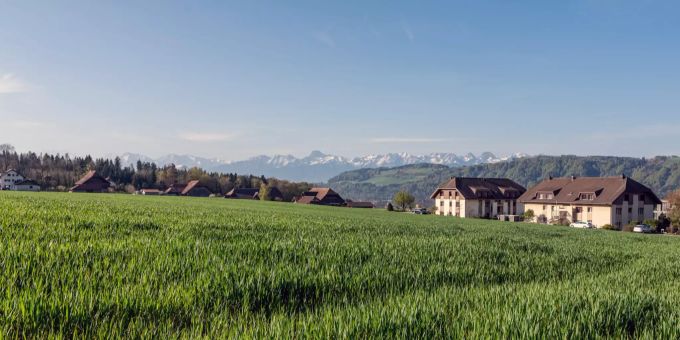 Blick auf den oberen Ortsteil von Rubigen und die Alpen - Rubigen. Blick auf den oberen Ortsteil von Rubigen und die Alpen - Rubigen.