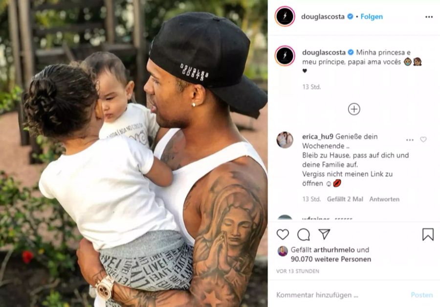 Douglas Costa hält seine Kinder auf dem Arm.